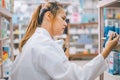 Pharmacist checking Checks Inventory of Medicine, Drugs, Vitamins with tablet and checking patient's prescription in modern