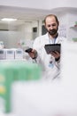 Pharmacist checking medication list on tablet computer while scanning pills packages bar code using store scanner Royalty Free Stock Photo
