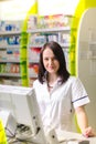 Pharmacist chemist woman show a pill. Pharmacy drugstore is background. Pretty, young laborant. Royalty Free Stock Photo