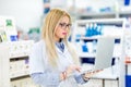 Pharmacist chemist woman standing in pharmacy drugstore and using laptop for network social media Royalty Free Stock Photo