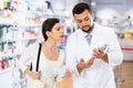 Pharmacist consulting woman buyer about drug