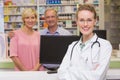 Pharmacist and costumers smiling at camera Royalty Free Stock Photo