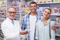 Pharmacist and costumers smiling looking at camera Royalty Free Stock Photo