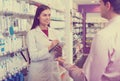 Pharmacist counseling customer about drugs