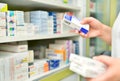 Pharmacist hand holding medicine box in pharmacy drugstore.