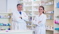 Pharmacist with his trainee standing with arms crossed