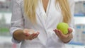 Pharmacist holding an apple and pills