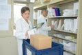 Pharmacist holding digital tablet in pharmacy stockroom