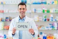 Pharmacist Holding An Open Sign