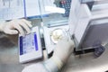 Laboratory worker in sterile rubber gloves, weighs the manufactured tablets on the control scales. Royalty Free Stock Photo