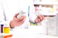 Pharmacist in pharmacy. Holding two bottles of pills. Royalty Free Stock Photo