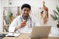 Pharmacist with pill bottle seating behind laptop in clinic Royalty Free Stock Photo