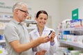 Pharmacist showing drug to senior man at pharmacy Royalty Free Stock Photo