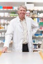 Pharmacist standing near medical counter. Portrait of handsome pharmacist smiling while standing near counter. Royalty Free Stock Photo