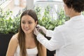 Pharmacist uses a specialized piercing gun to create a new earlobe piercing