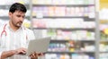 Pharmacist using laptop computer at pharmacy. Royalty Free Stock Photo