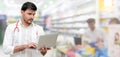 Pharmacist using laptop computer at pharmacy. Royalty Free Stock Photo