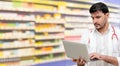 Pharmacist using laptop computer at pharmacy. Royalty Free Stock Photo