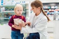 Pharmacist woman with child customer and her plush toy Royalty Free Stock Photo