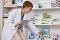 Pharmacist woman, tablet and medicine shelf to check inventory and product information search. Person with pharmacy app