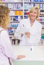 Pharmacist writing prescription in front of a customer Royalty Free Stock Photo