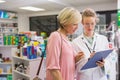 Pharmacist writing prescription with her customer Royalty Free Stock Photo