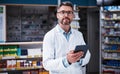 The pharmacists digital assistant. Portrait of a handsome mature pharmacist using a digital tablet in a pharmacy.