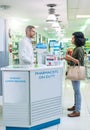 Pharmacists are educated to recognize signs and symptoms of diseases. a mature pharmacist assisting a young woman in a