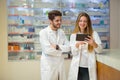 Pharmacists using digital tablet while checking medicine Royalty Free Stock Photo