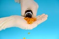 Pharmacological worker in medical gloves pours pills from the bottle on the hand