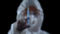 Pharmacologist showing syringe at camera against black background, illegal lab Royalty Free Stock Photo