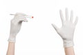 Pharmacology and Medical theme: doctor's hand in a white glove holding tweezers with red pill capsule isolated on white background Royalty Free Stock Photo