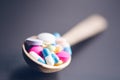 Pharmacy background on a black table with measuring tape. Tablets on a wooden spoon. Pills. Medicine and healthy. Close up of caps