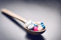 Pharmacy background on a black table with measuring tape. Tablets on a wooden spoon. Pills. Medicine and healthy. Close up of caps