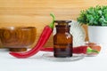 Pharmacy bottle with red chili pepper extract tincture, infusion, oil and fresh chili pepper pods. Royalty Free Stock Photo