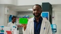 Pharmacy consultant holding greenscreen on box