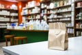 Pharmacy counter paper bag amid health products, blurred store backdrop