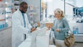 Pharmacy Drugstore Checkout Cashier Counter: Black Male Pharmacist Service Senior Female Customer Royalty Free Stock Photo