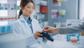 Pharmacy Drugstore Checkout Cashier Counter: Professional Asian Female Pharmacist Sells Medicine in Royalty Free Stock Photo