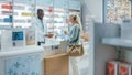 Pharmacy Drugstore Checkout Counter: Professional Black Male Pharmacist Provides Service, Sells Royalty Free Stock Photo