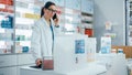 Pharmacy Drugstore Counter: Portrait of Helpful Caucasian Female Pharmacist Talking on the Mobile Royalty Free Stock Photo