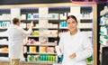 In pharmacy, female specialist holds and shows new effective remedy for moisturizing delicate skin
