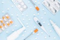 Pharmacy healthcare pattern - white plastic sprays, pills, silver antibiotic, orange syringe, 36,6 thermometer on blue color. Royalty Free Stock Photo