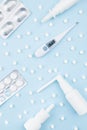 Pharmacy healthcare pattern - white plastic sprays, pills, silver antibiotic, syringe, 36,6 thermometer on blue color, top view. Royalty Free Stock Photo