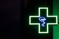 Pharmacy Neon Green Sign by Night. Bowl of Hygieia is one of the symbols of Pharmacy.