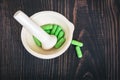 Pharmacy pestle and mortar with green capsules. Royalty Free Stock Photo