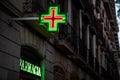 Pharmacy signs illuminated at night on spanish architecture facade Royalty Free Stock Photo