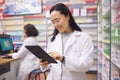 Pharmacy, tablet and asian pharmacist woman for medicine management, stock research and inventory. Digital technology Royalty Free Stock Photo