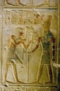 Pharoah Seti presenting lotus flowers to god Horus