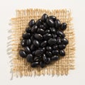 Black Turtle Bean legume. Close up of grains over burlap. Royalty Free Stock Photo